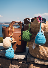 Bijoux de sac Les Félicités @lesfelicitesofficial jewels for bags de forme ronde et moelleuse avec des coloris écru bleu et vert sur un sac ou un panier et rubans avec des mots bienveillants @lesfelicites Les Félicités