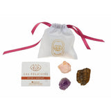 Trois pierres de protection: le quartz rose, l'améthyste et l'oeil du tigre et une carte explicative de leurs vertus.