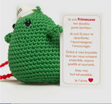frimousse petite poupée  de forme ronde de couleur verte crochetée en fil de coton à la main à bali dans un atelier artisanal peut servir de bijoux de sac ou décorer un bureau accompagner de rubans imprimés de mots bienveillants @lesfelicitesofficial 