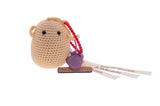 Frimousse petite poupée  de forme ronde de couleur écru  crochetée en fil de coton à la main à bali dans un atelier artisanal peut servir de bijoux de sac ou décorer un bureau accompagner de rubans imprimés de mots bienveillants @lesfelicites Les Félicités 