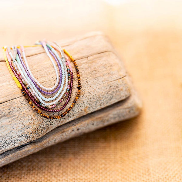 Bracelets porte-bonheur avec pierres de protection sur bois naturel